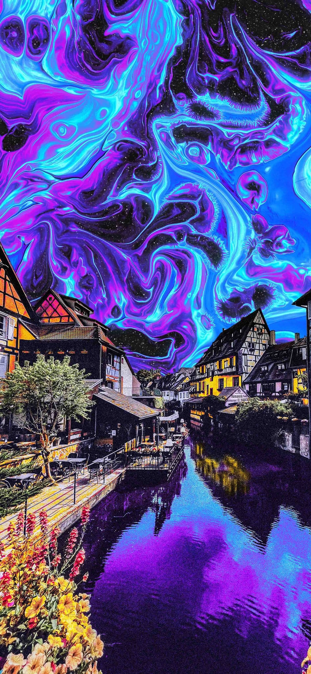 Half-timbered houses line a purple canal beneath a swirling blue and violet aurora borealis with foreground flowers.