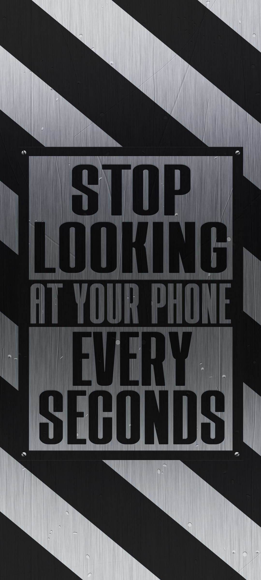 Metallic warning sign with black and white diagonal stripes reading stop looking at your phone every second.