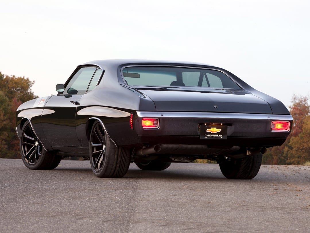 Black 1970 Chevrolet Chevelle SS with chrome bumpers and modern black wheels parked on a rural asphalt road.