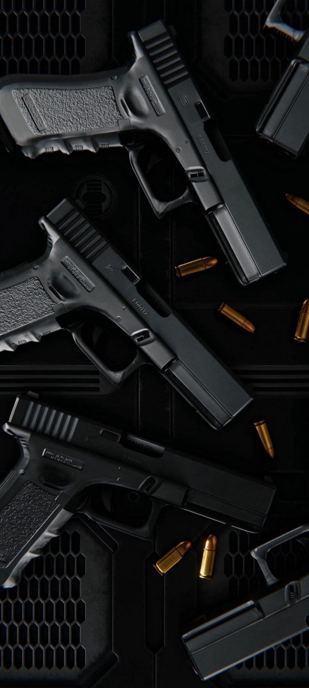 Black Glock pistols and brass ammunition rounds scattered across a dark grey hexagonal textured surface.