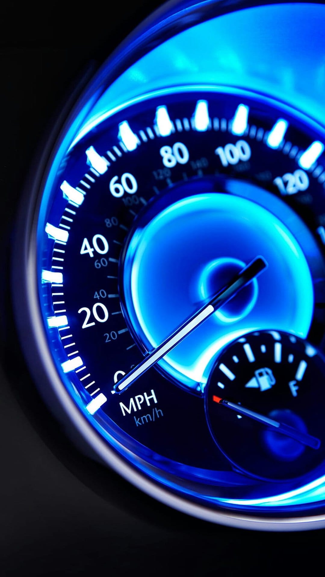 Luminous blue digital speedometer displaying MPH and km/h markings on a dark vehicle instrument cluster dashboard.