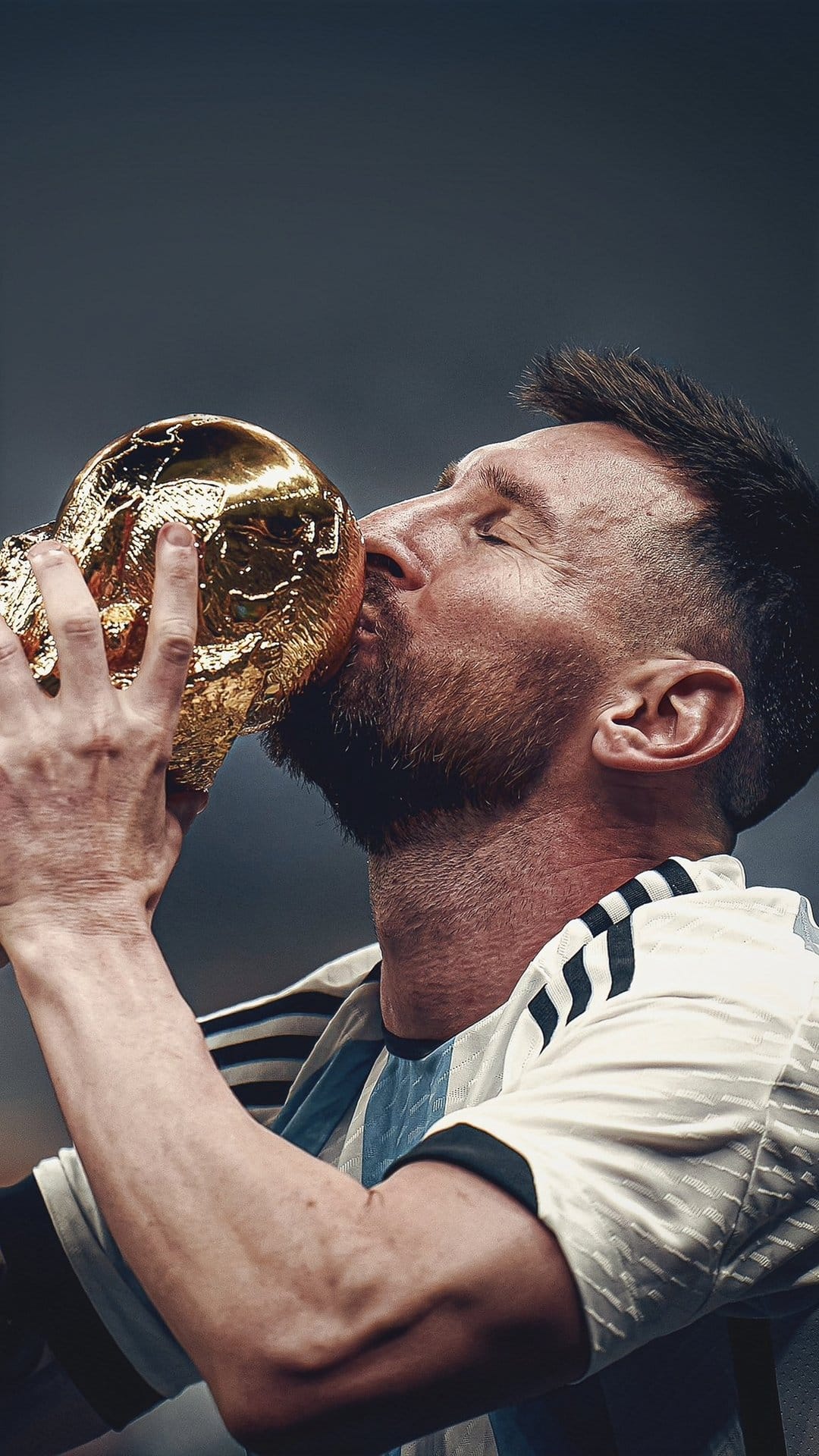Lionel Messi kisses the gold World Cup trophy while wearing the blue and white striped Argentina national jersey.