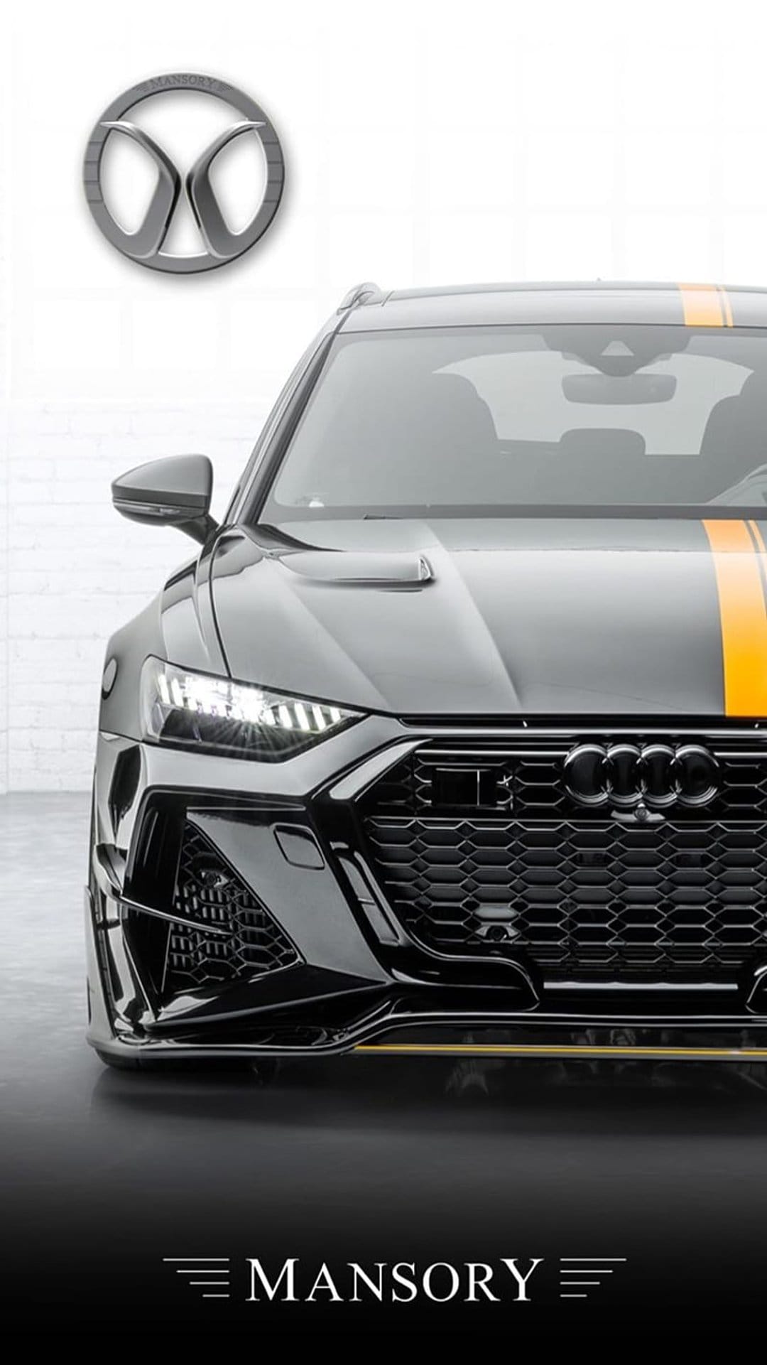 Mansory Audi RS6 Avant in black with orange racing stripes shows an aggressive front grille and widebody kit.