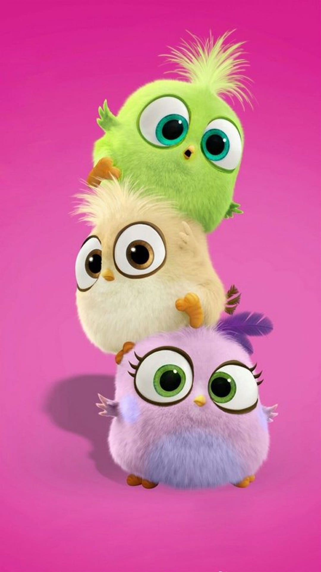 Stacked green, yellow, and purple baby birds with large expressive eyes sit against a solid pink background.