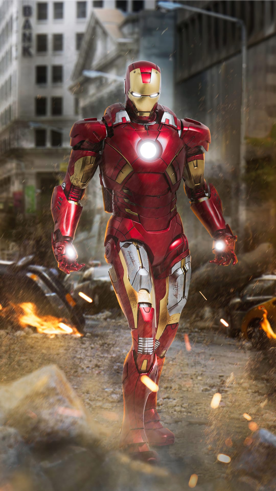 Iron Man in red and gold armor stands amid burning city ruins with a glowing arc reactor and smoke-filled air.