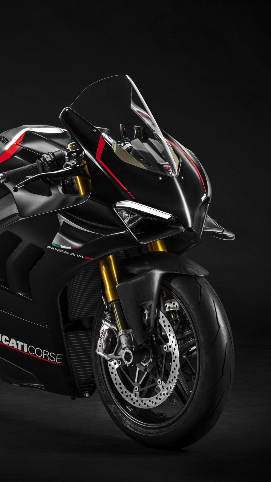 Matte black Ducati Panigale V4 SP motorcycle with red accents and gold forks against a dark studio background.
