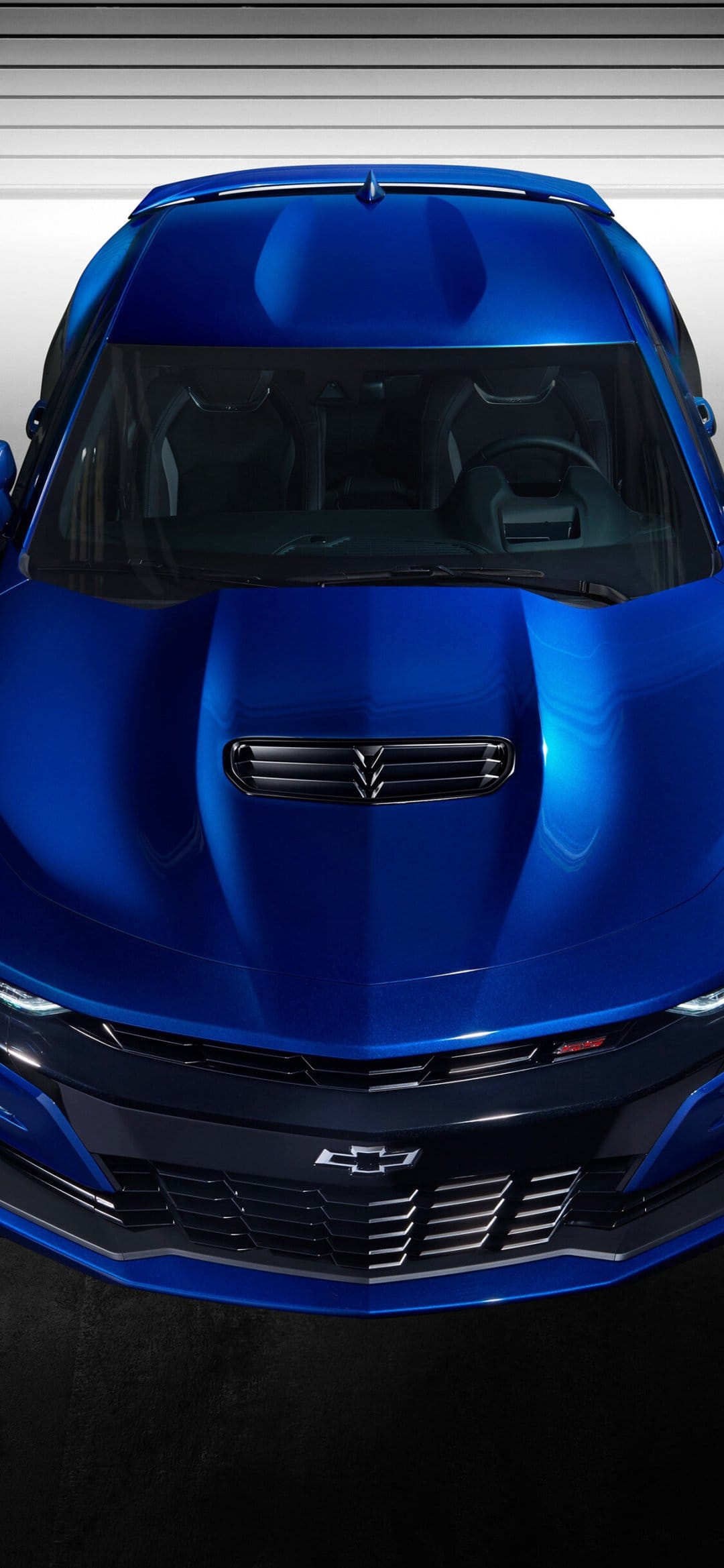 Top-down view of a metallic blue Chevrolet Camaro showing the muscular hood, black grille, and sleek roof lines.