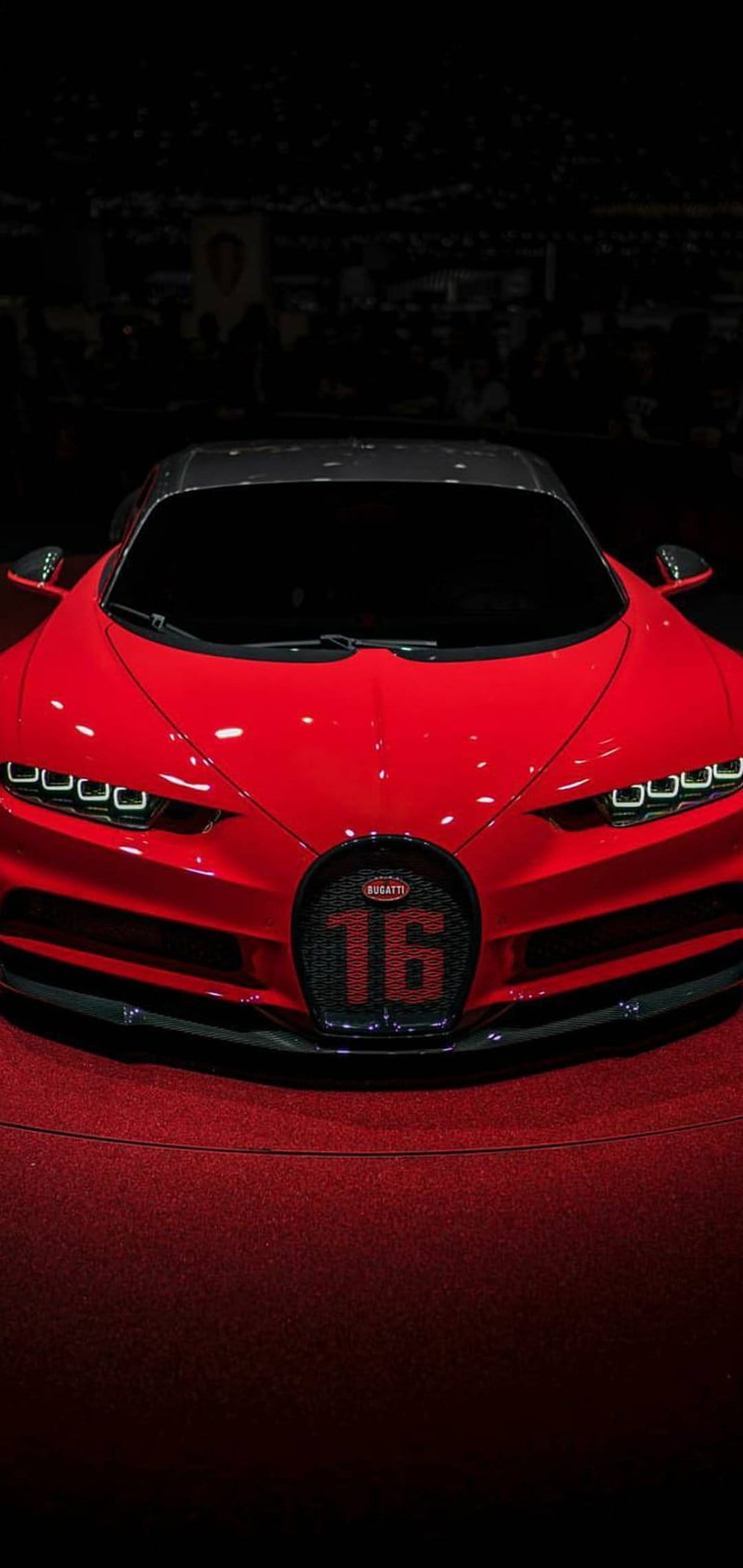Bugatti Chiron Super Sport 300+ in red featuring a carbon fiber roof and sharp LED headlights on a plush carpet.