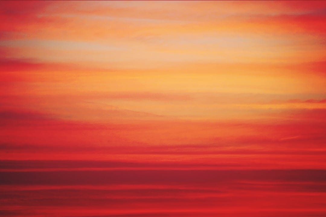 Fiery red and orange clouds stretch horizontally across a twilight sky in a vivid vertical gradient.