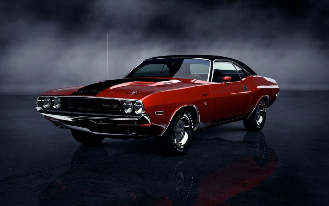 Red 1970 Dodge Challenger R/T with black accents on a dark reflective surface under a moody cloud-filled sky.