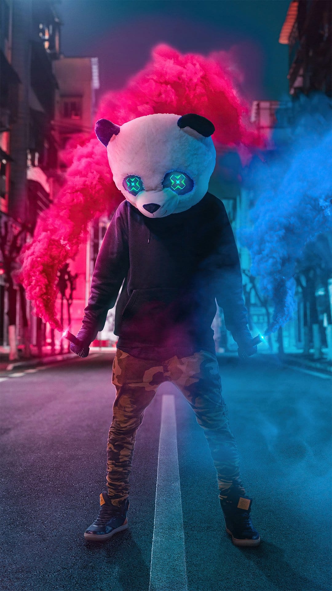 Panda mask with glowing blue X eyes surrounded by red and blue smoke in a dark urban street setting.