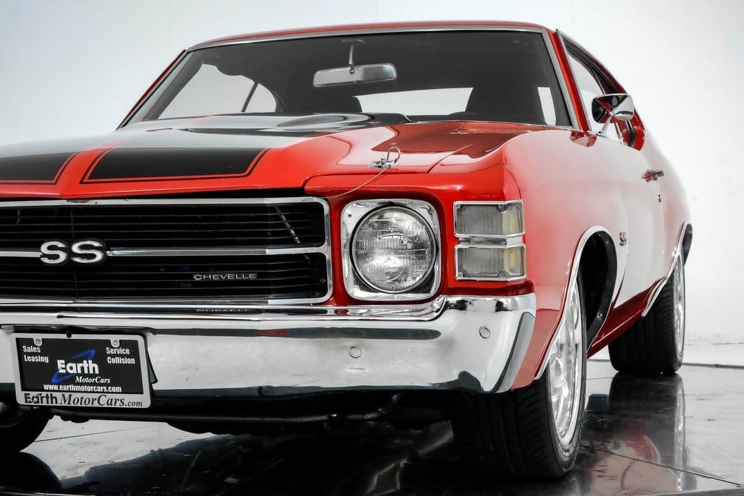 Red Chevrolet Chevelle SS front end with black racing stripes, chrome bumper, and single round headlights.