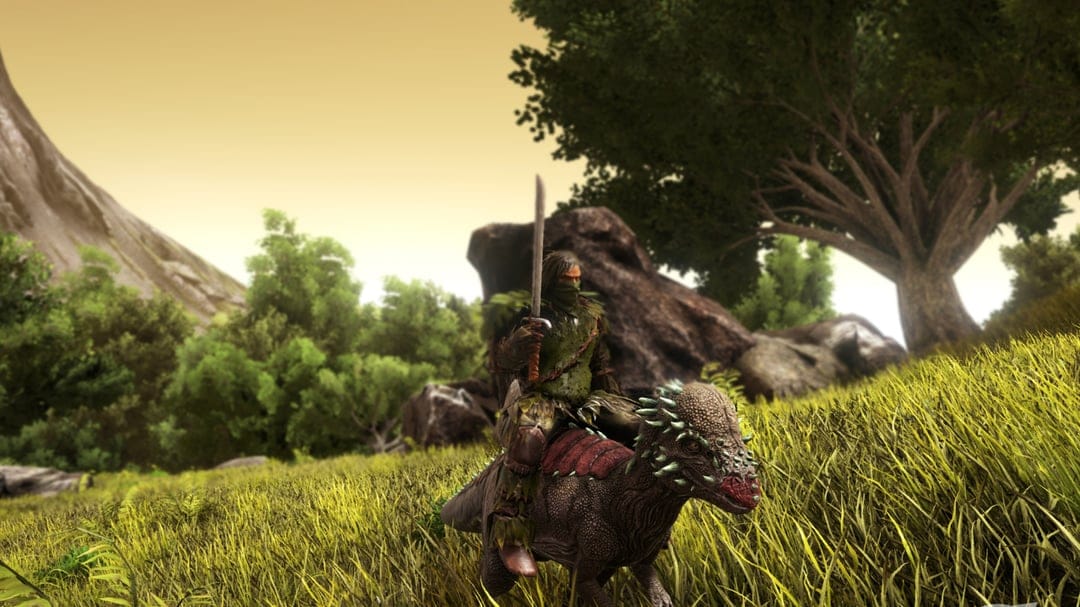 Warrior in ghillie armor riding a Pachycephalosaurus dinosaur through a field with a raised sword at sunset.