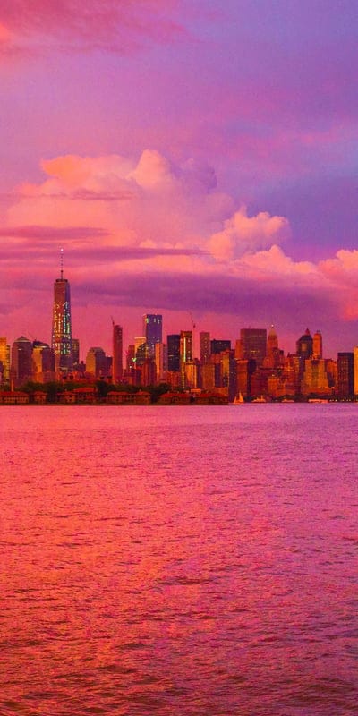 New York City, skyline, sunset, urban, illuminated, harbor, iconic, travel, USA, buildings, cityscape, reflections, vibrant, serene, metropolitan, dramatic, beautiful, architecture, water, sky, colorful, panorama