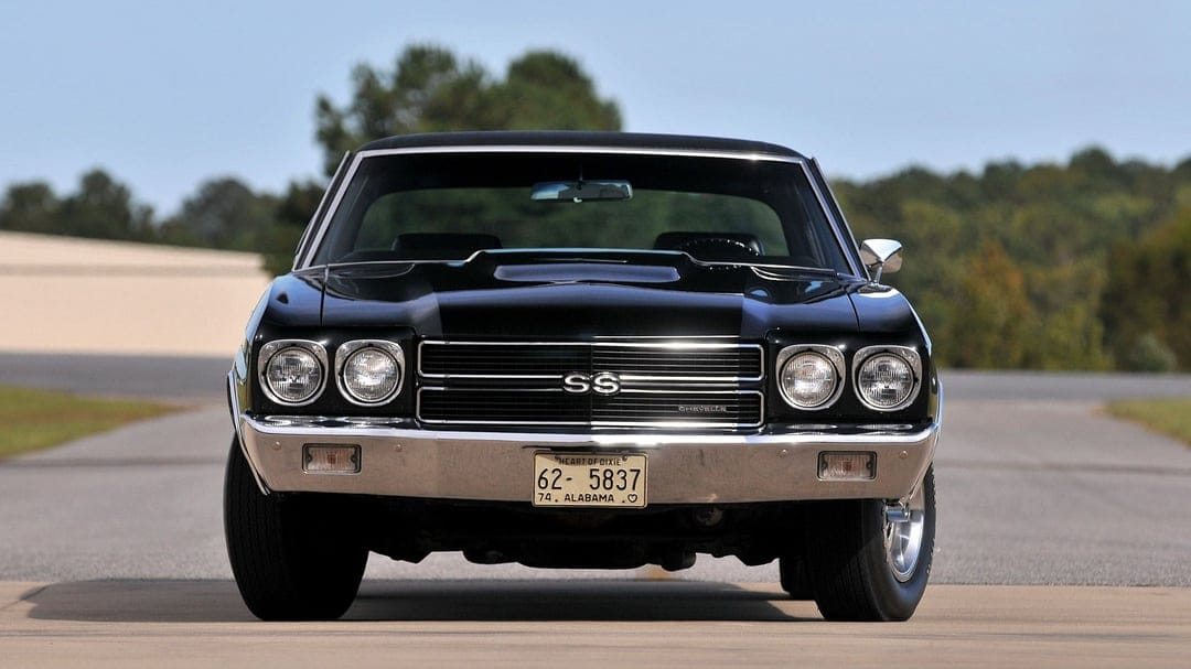 Front view of a black 1970 Chevrolet Chevelle SS with chrome bumpers and dual headlights on an open road.