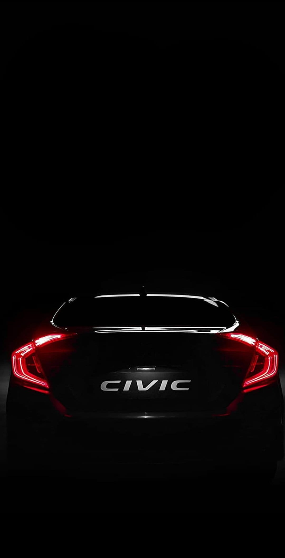 Red C-shaped LED taillights and a silver Civic emblem on a black car body in a dark, moody night setting.