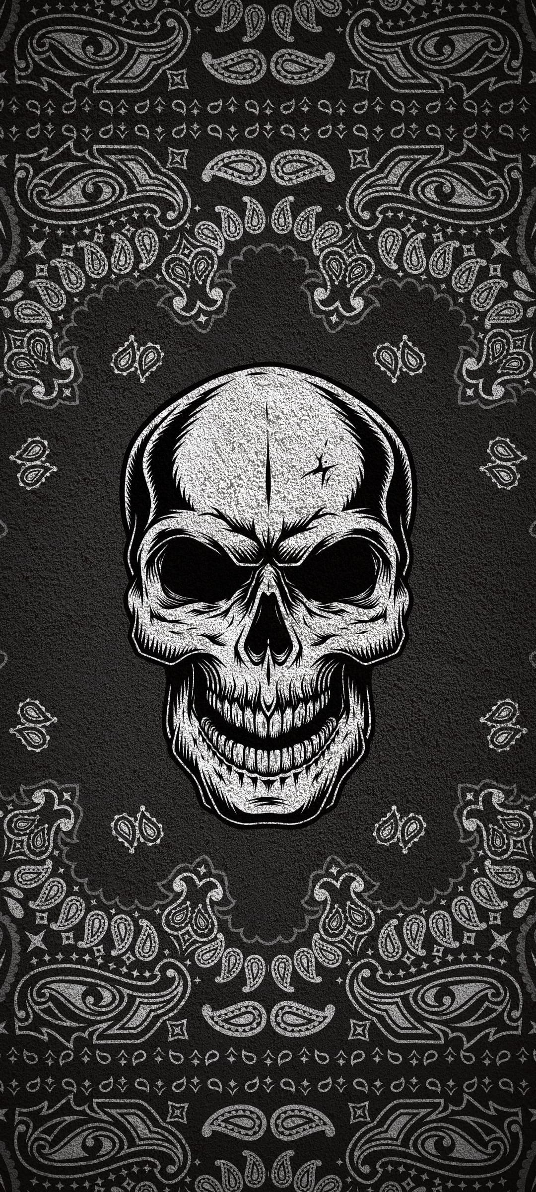 Human skull centered on a black paisley bandana background with intricate white shading and swirling patterns.