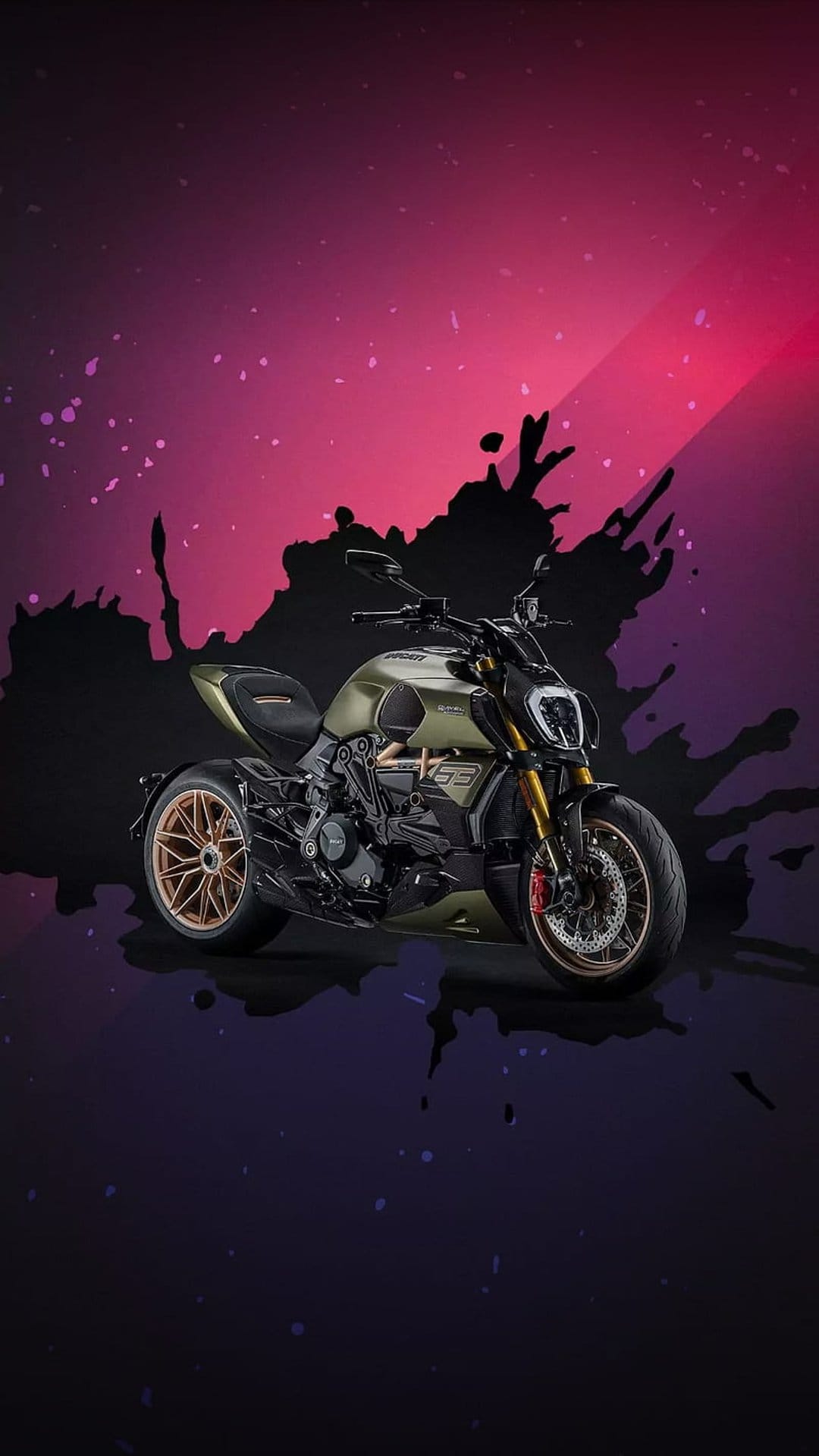 Olive green Ducati motorcycle with golden wheels stands before an abstract pink and purple paint splash background.