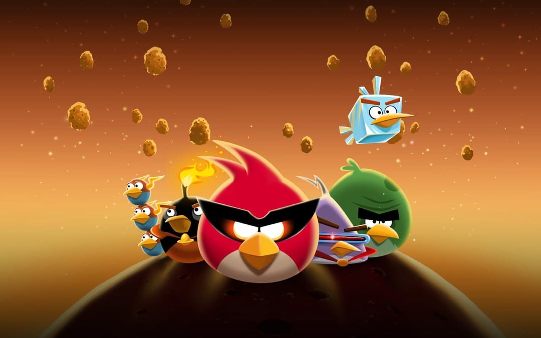 Angry Birds Space characters stand on a rocky asteroid surface under a warm orange and dark starry sky.