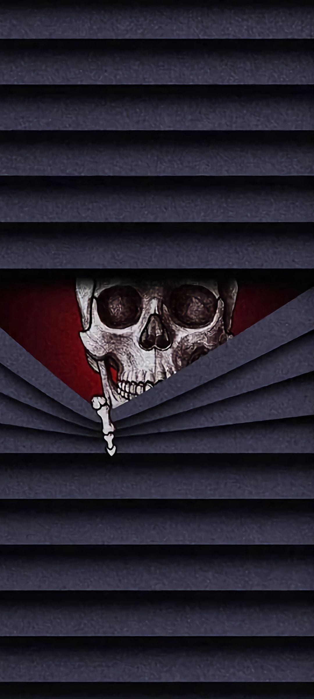 Human skull with hollow eyes peeking through horizontal window blinds against a deep crimson background.