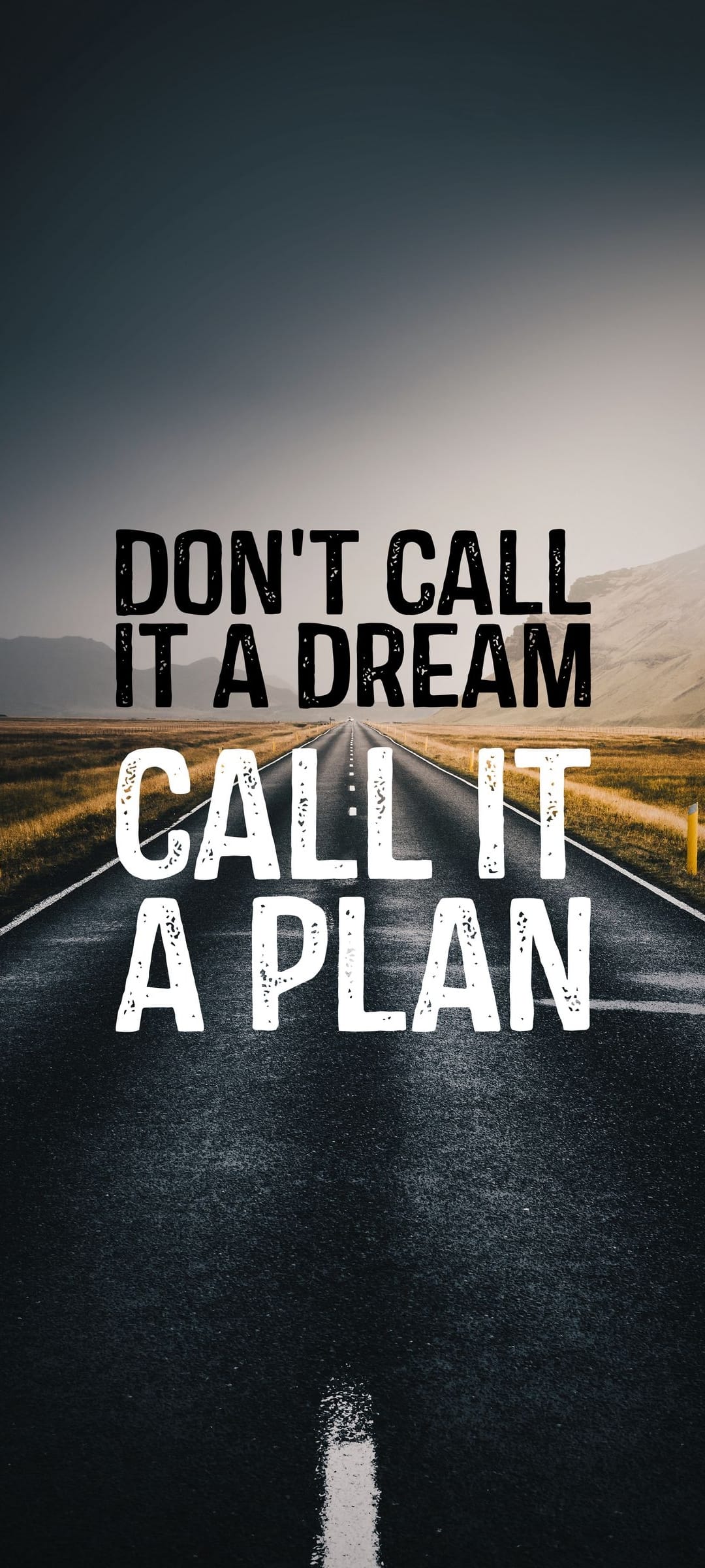 Asphalt road leading toward distant blue mountains with white serif text reading Don't Call It A Dream Call It A Plan.