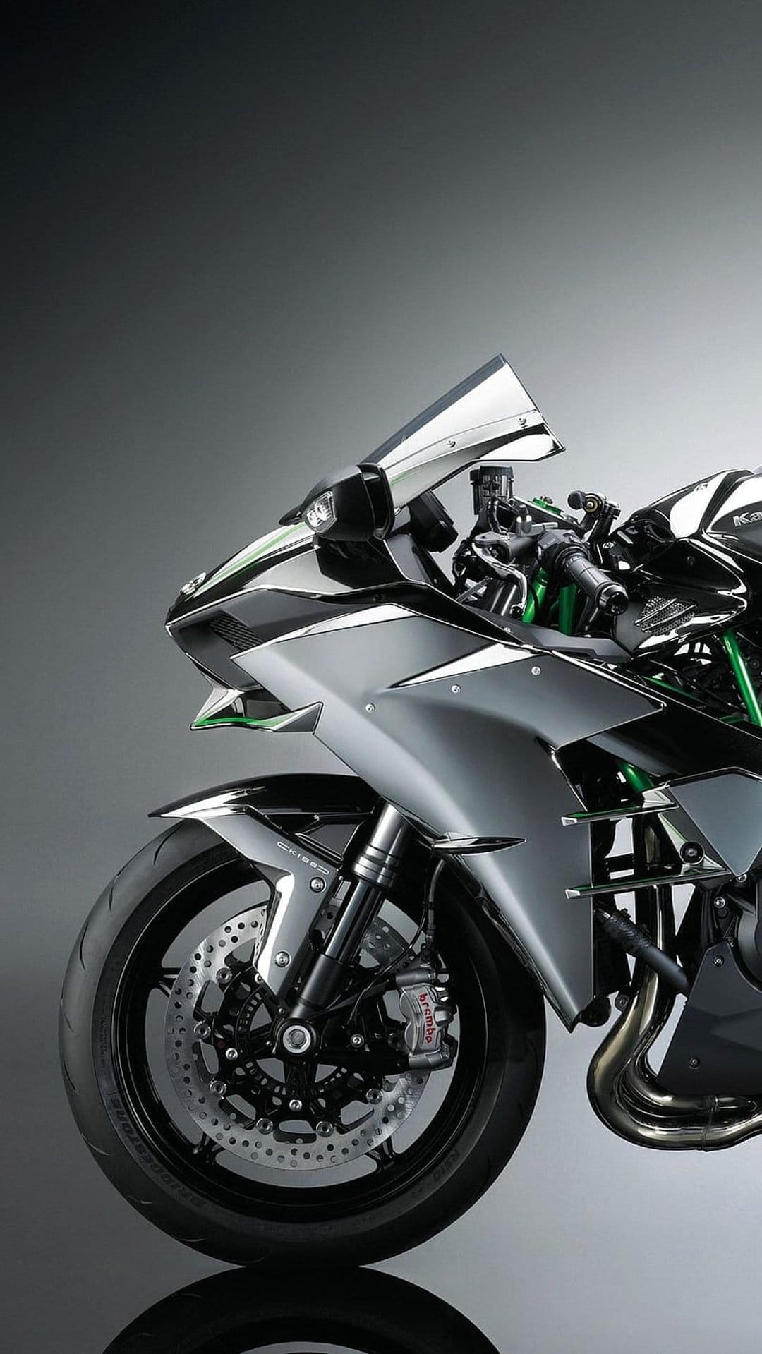 Kawasaki motorcycle with green frame details, polished silver fairings, and a prominent front disc brake system.