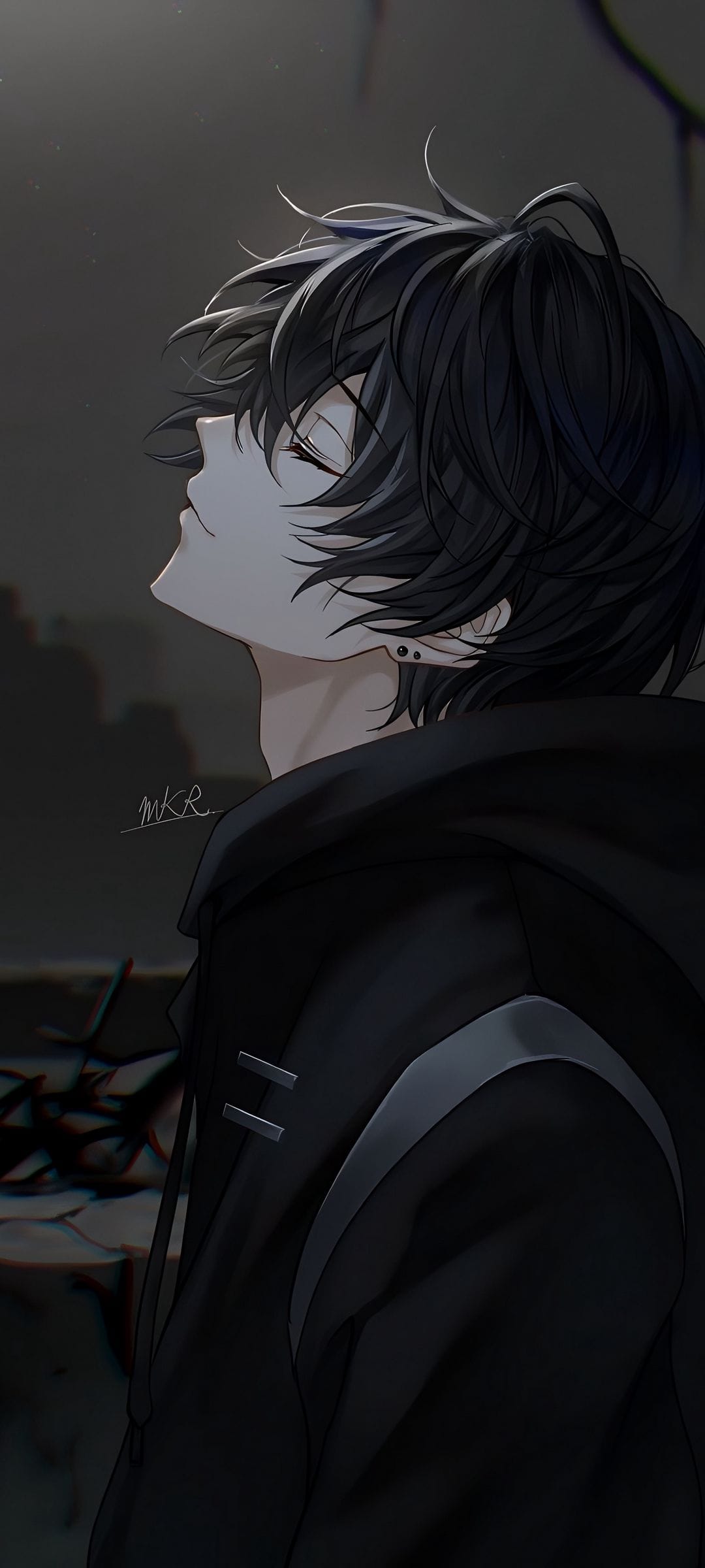 Young man with messy black hair and closed eyes looking upward while wearing a black hooded jacket and earring.