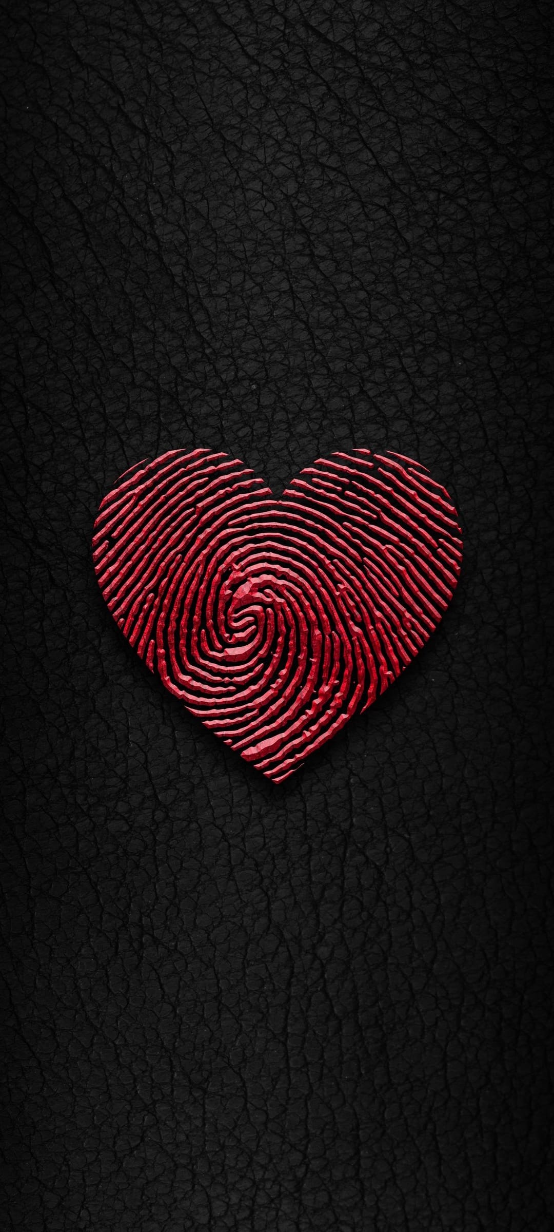 Red fingerprint heart centered on a dark black leather textured background with high contrast macro details.