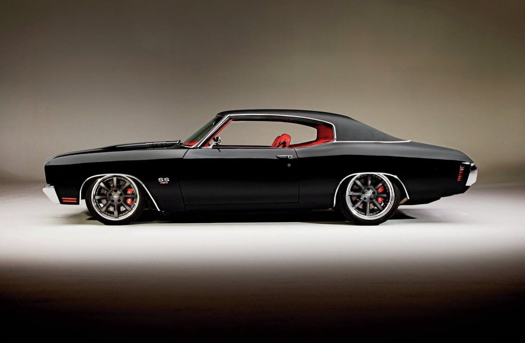 Black 1970 Chevelle SS muscle car profile featuring a red interior and custom wheels in a studio environment.
