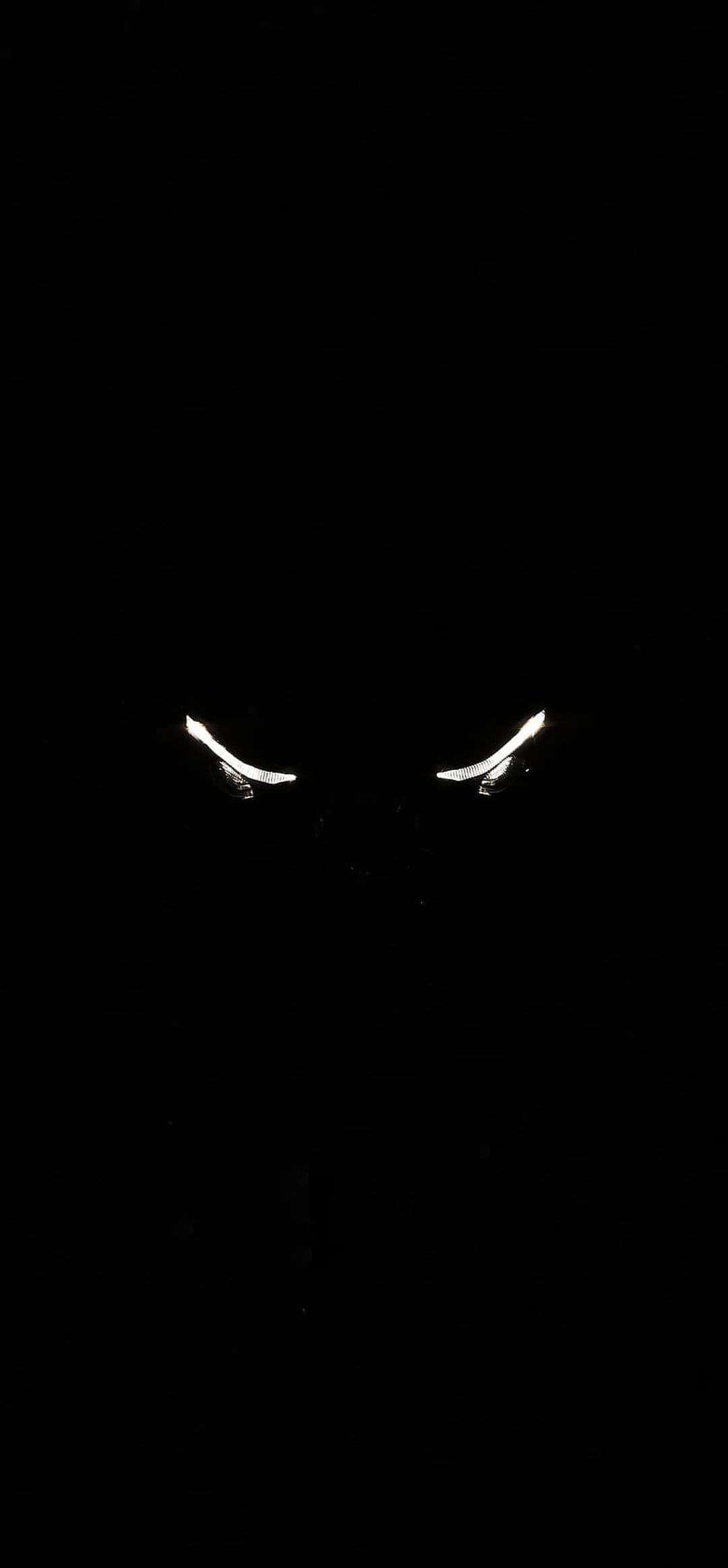 Two bright white curved lines resembling glowing eyes peer through a pitch black void with high contrast.