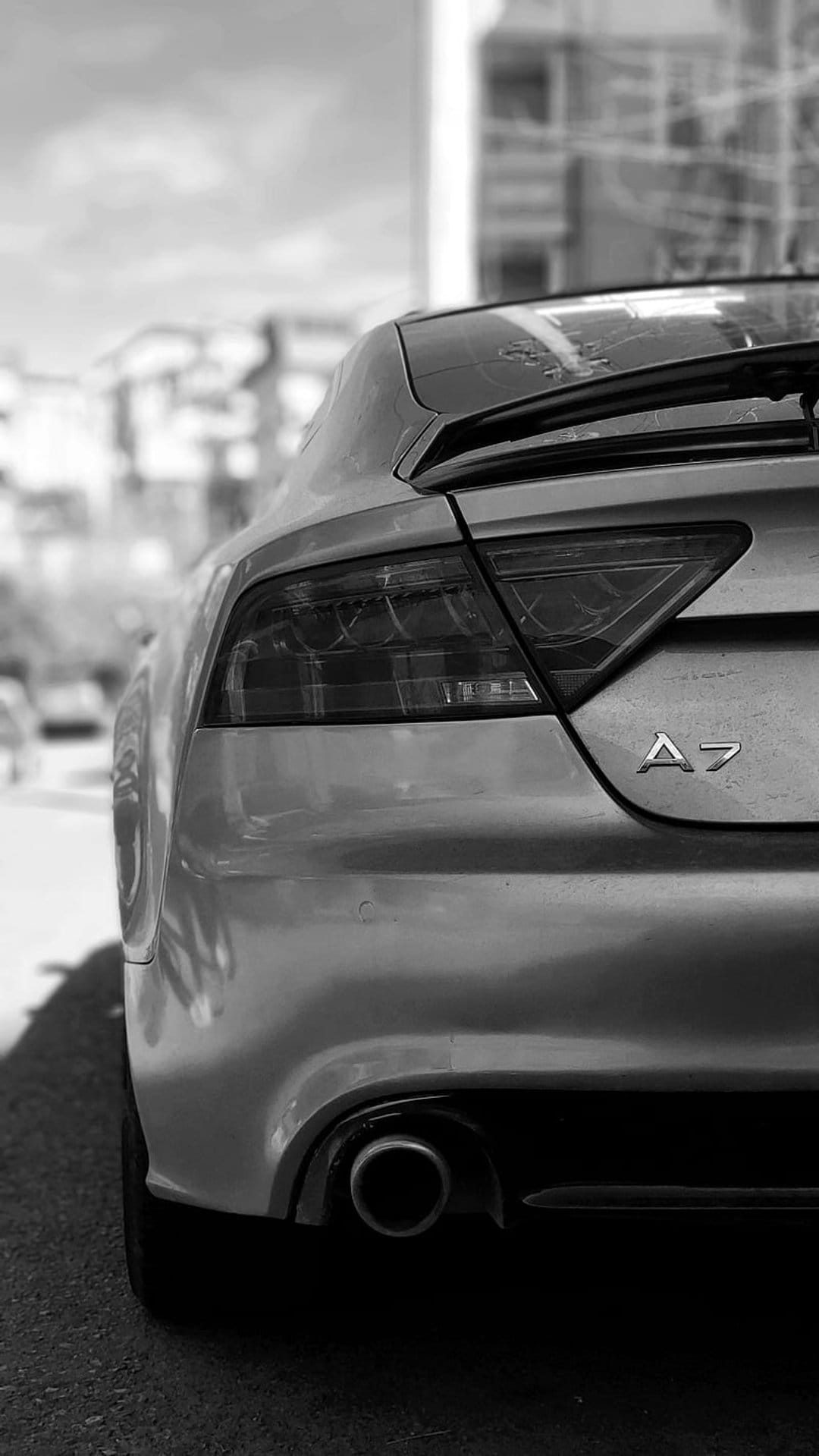Audi A7 rear taillight and A7 emblem shown in a high-contrast black and white close-up with chrome textures.