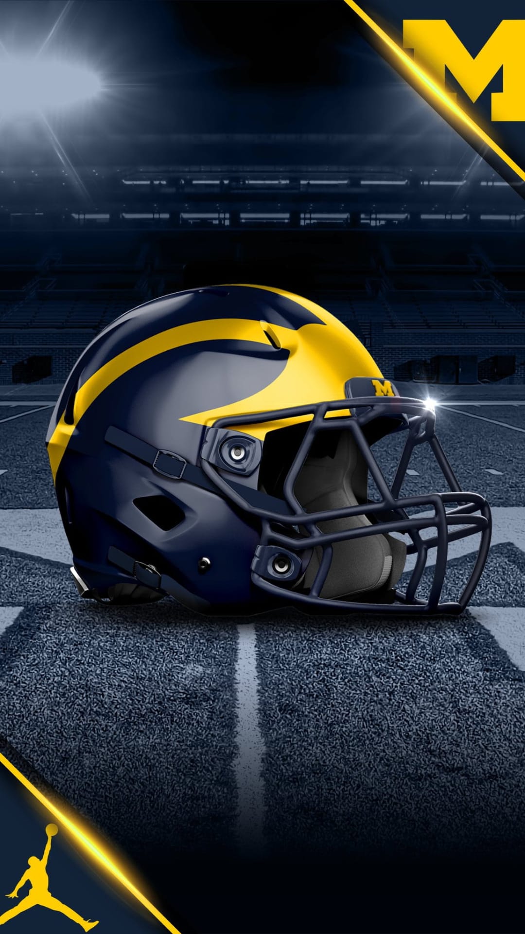 Michigan Wolverines football helmet with yellow wings on a green turf field under bright stadium floodlights.
