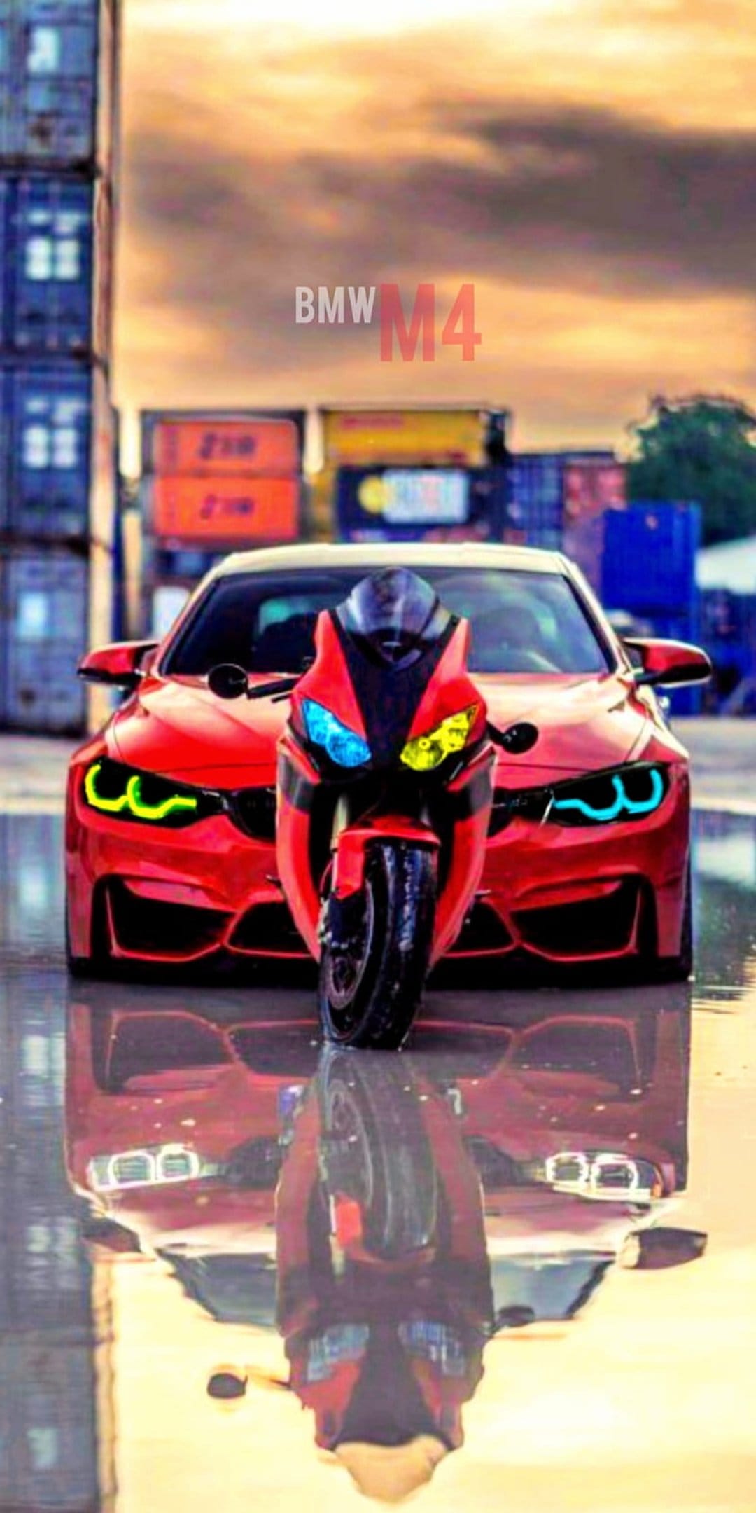 Red BMW M4 and sportbike reflect on wet pavement with shipping containers and a cloudy sky in the background.