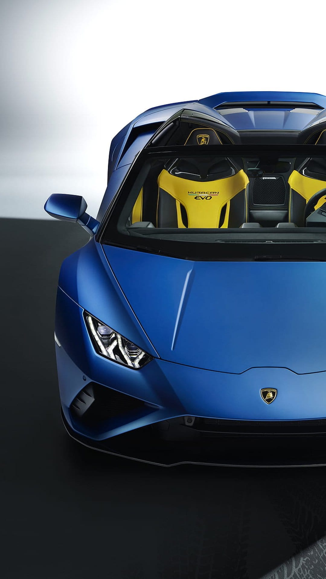 Blue Lamborghini Huracan EVO Spyder front end with yellow and black leather racing seats in the cockpit.