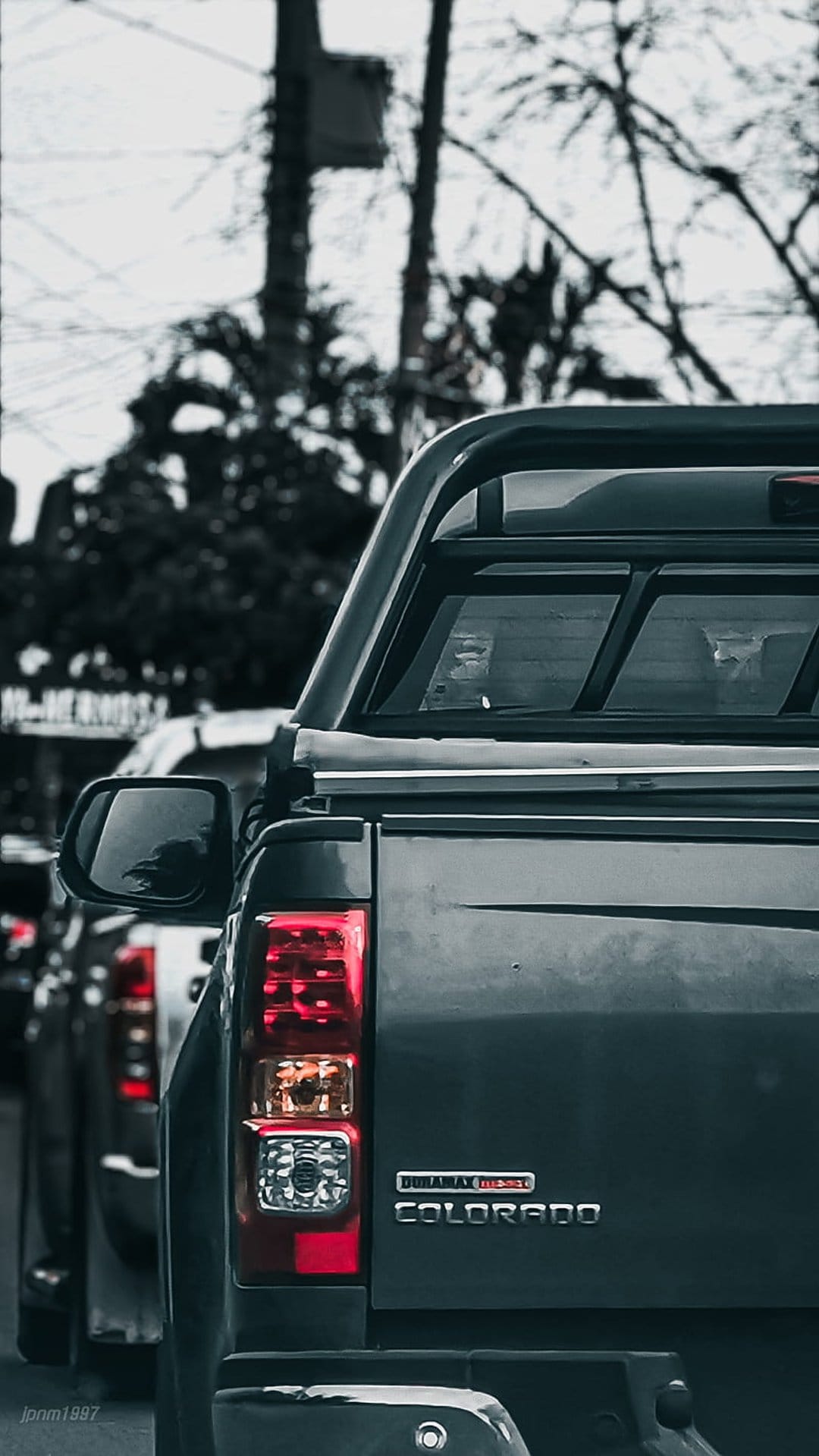 Dark grey Chevrolet Colorado truck rear showing the red taillight, chrome badging, and Duramax Diesel emblem.