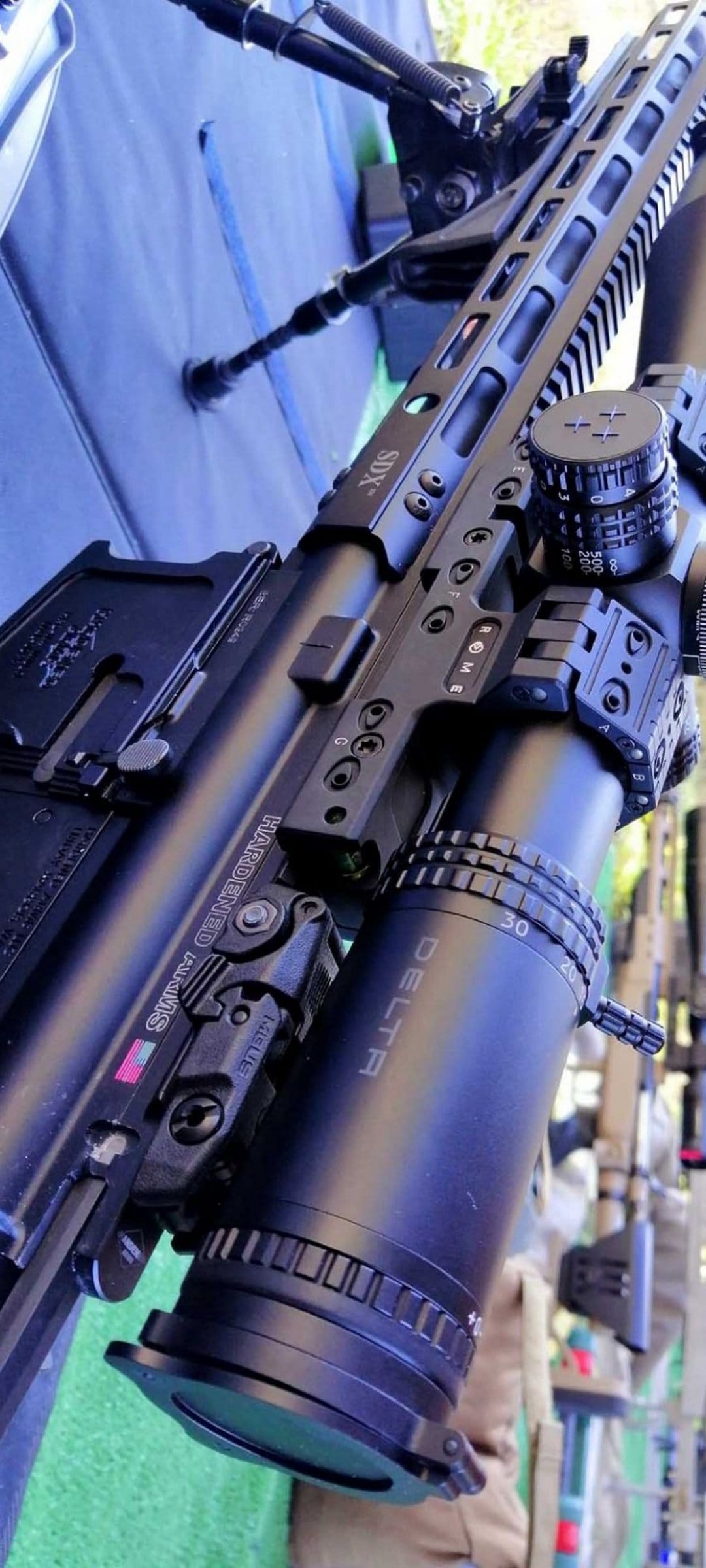 AR-15 tactical rifle with a DELTA optic and SDX rail system rests on a bipod highlighting technical parts.