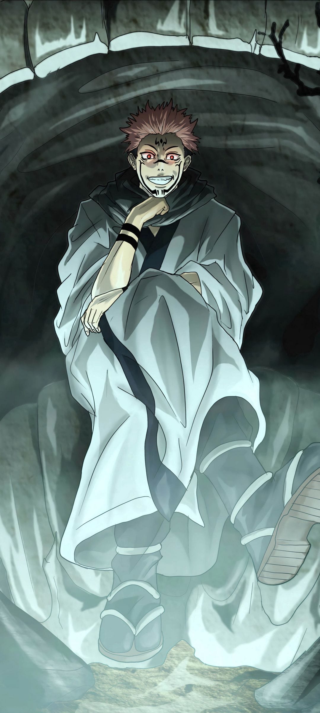 Ryomen Sukuna sits with a hand on his chin, featuring red spiky hair, facial markings, and a taunting smirk in a cave.