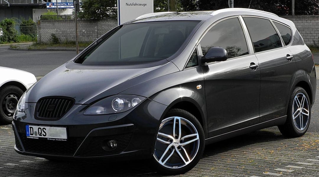 Dark gray SEAT Altea XL parked on brick pavers with five-spoke alloy wheels and soft daylight reflections.
