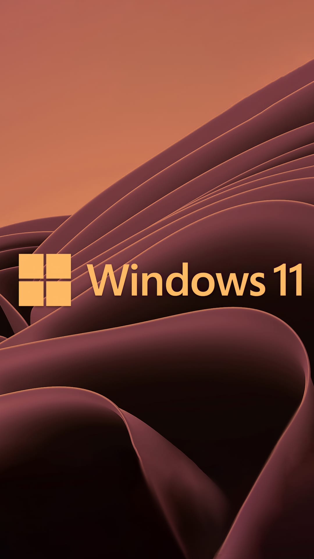 Windows 11 logo glows in warm amber over cascading dark orange silk folds and flowing bronze fabric textures.
