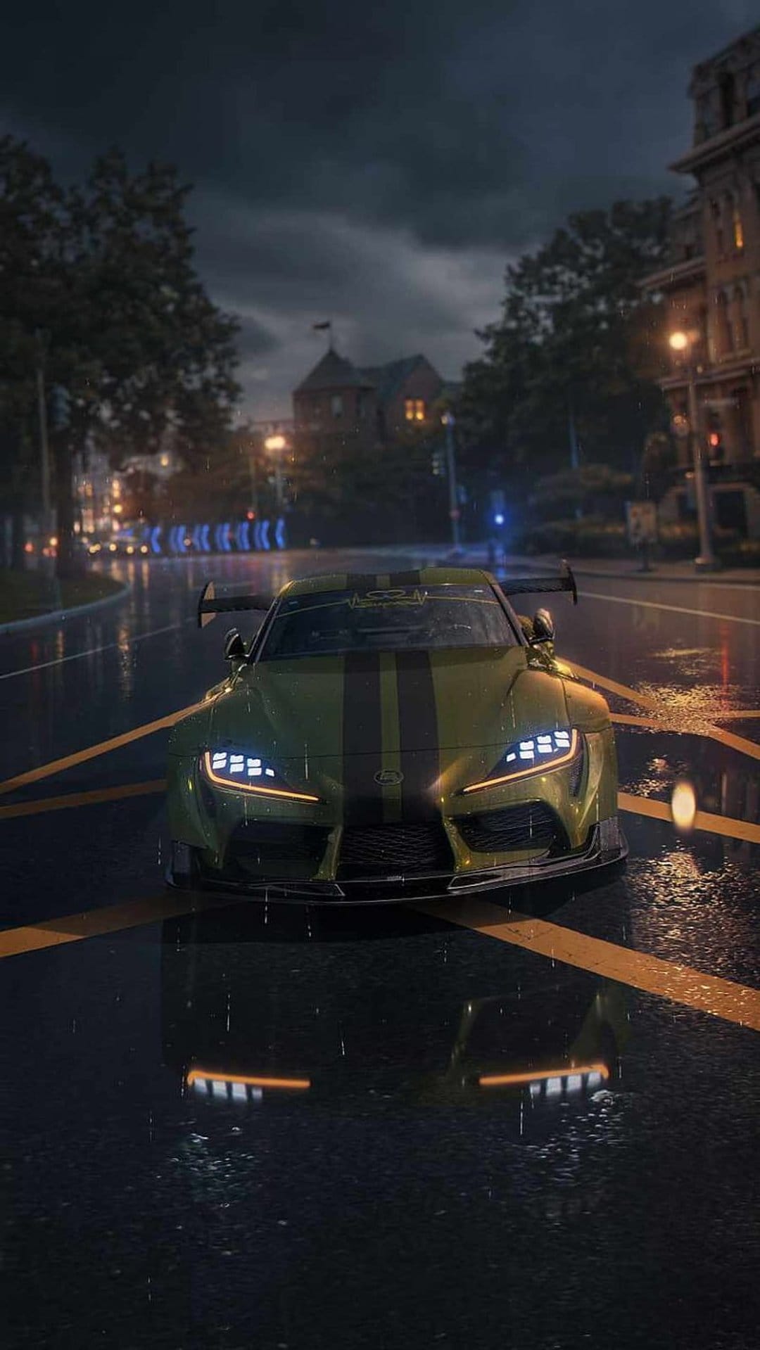 Green Toyota Supra with black stripes parked on a wet, reflective city street at night under warm streetlights.