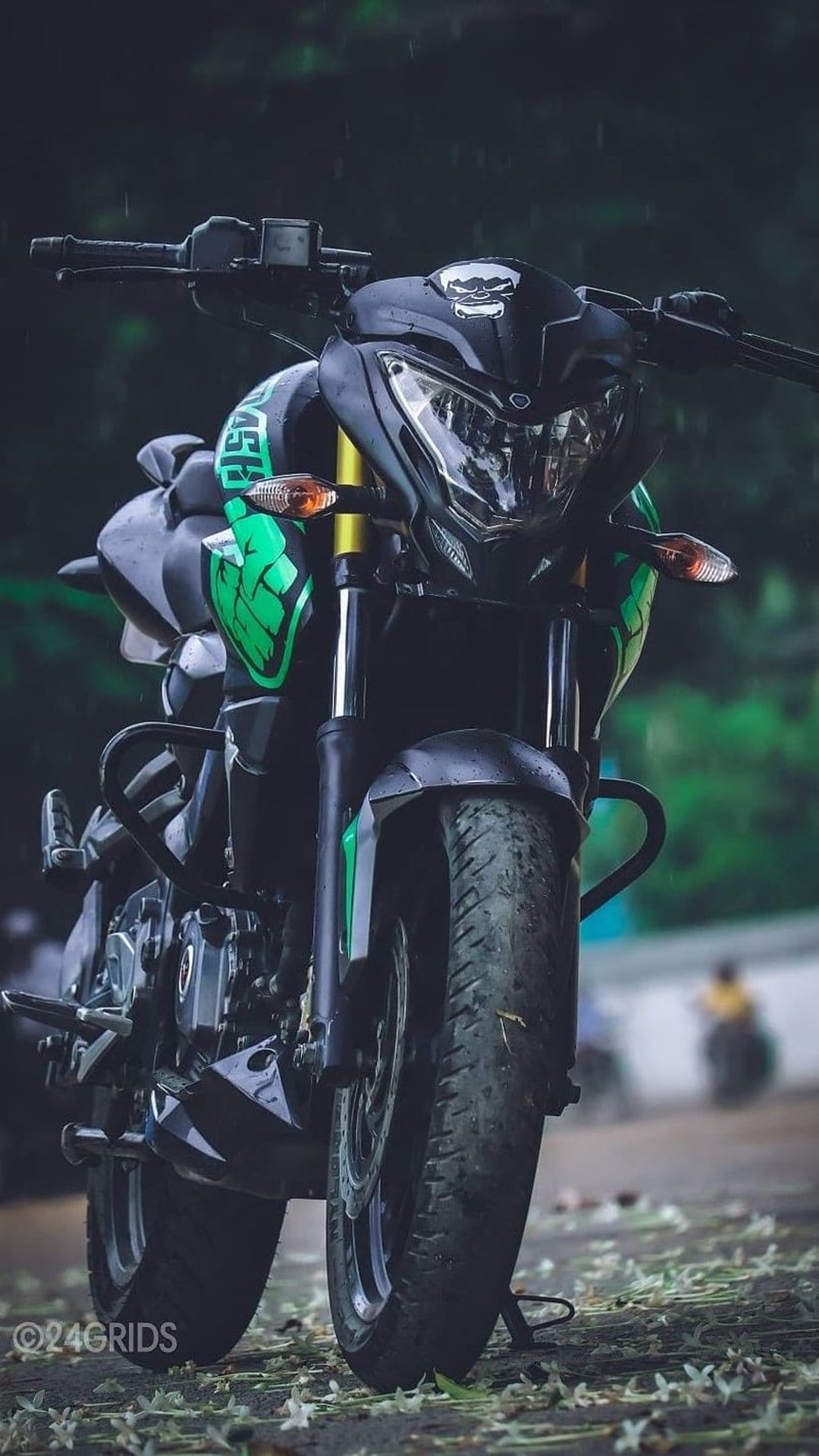 Green and black sportbike front fairing on wet pavement with white flowers during a moody rain shower.