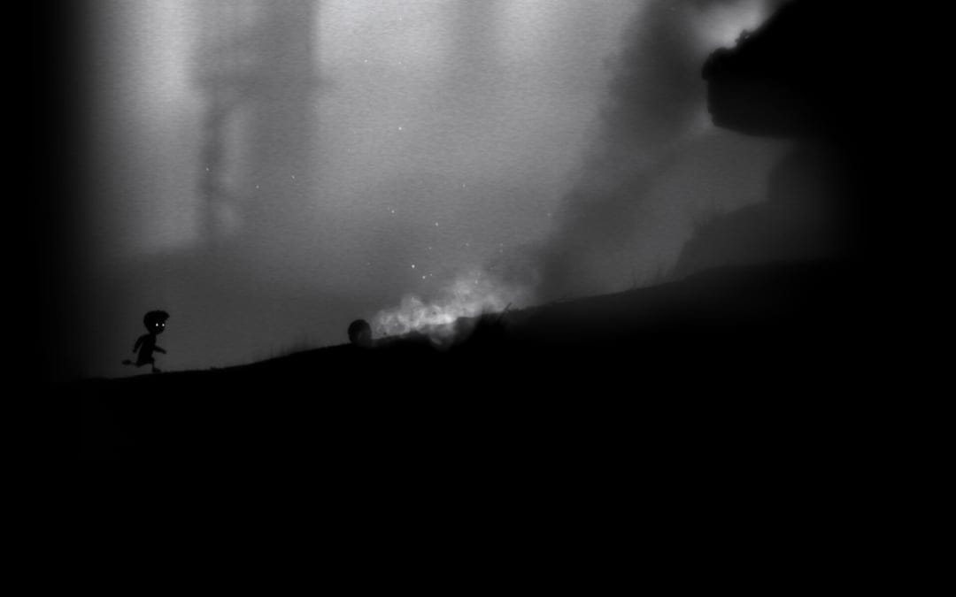 Silhouette of a boy running on a dark hill toward white smoke in a misty, monochrome cinematic landscape.