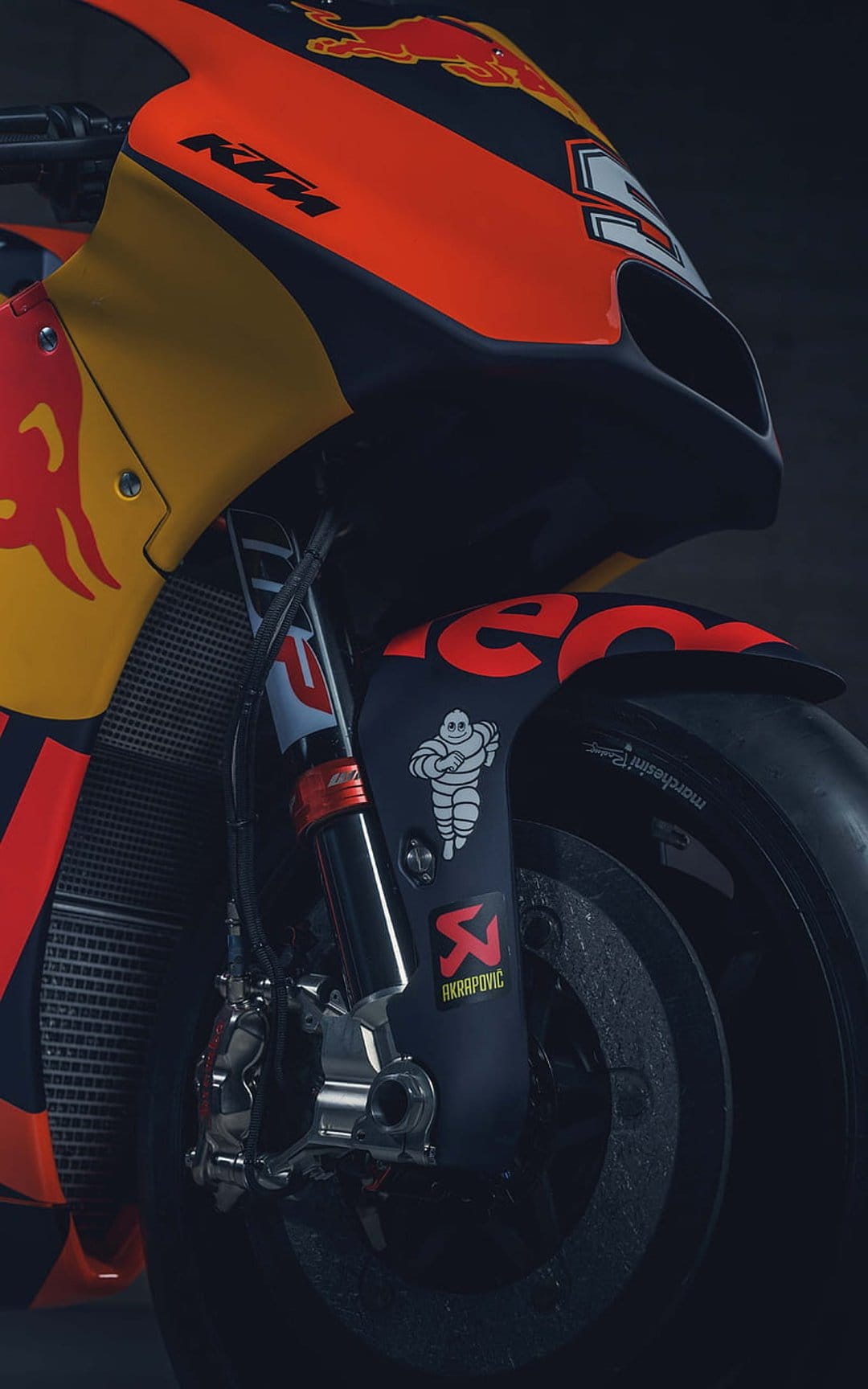 KTM racing motorcycle front fairing with Red Bull logos, orange suspension forks, and aerodynamic bodywork.
