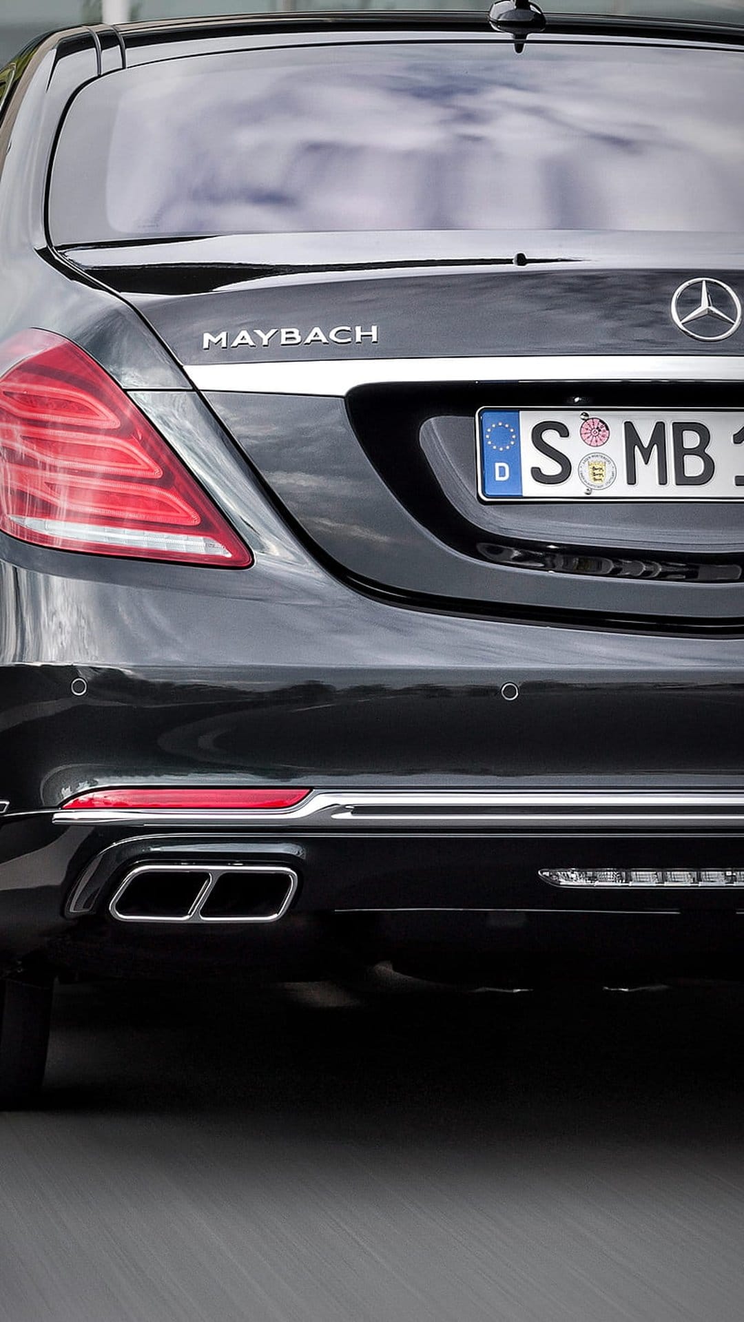 Black Maybach S-Class rear bumper featuring dual chrome exhaust outlets, silver emblem, and German license plate.