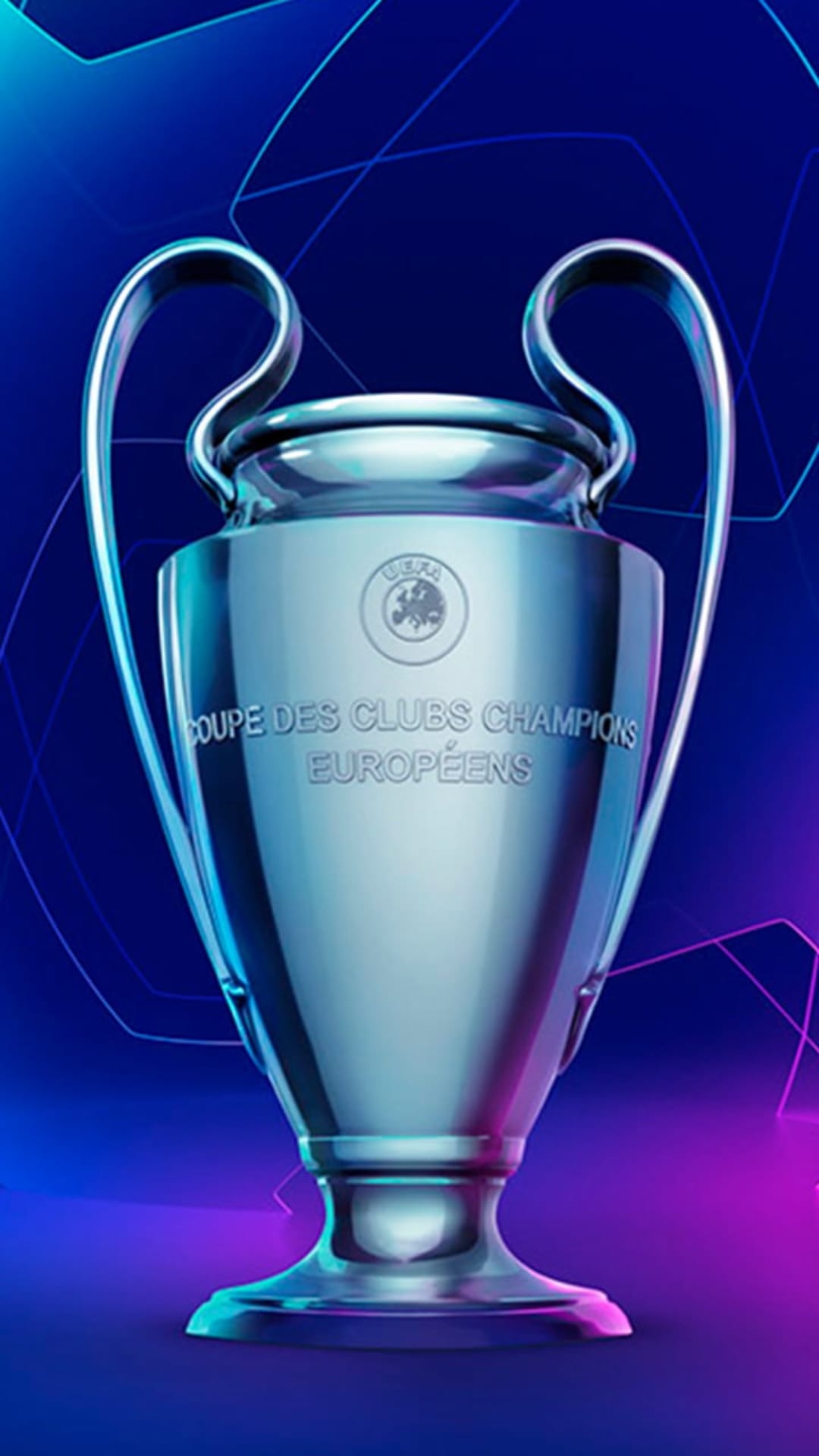 Silver Champions League trophy with large handles stands prominently against a blurred stadium light backdrop.