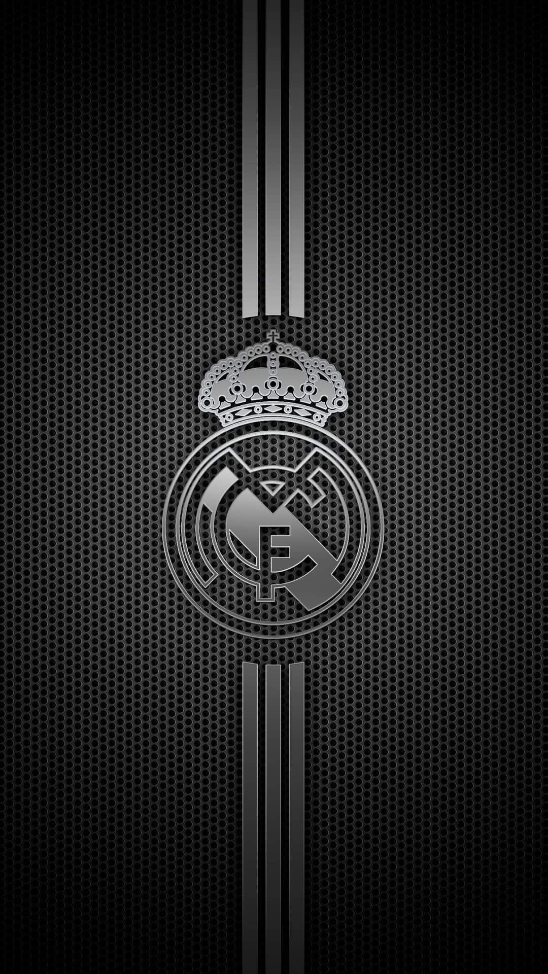 Real Madrid metallic silver crest centered on a dark gray perforated metal background with three vertical stripes.