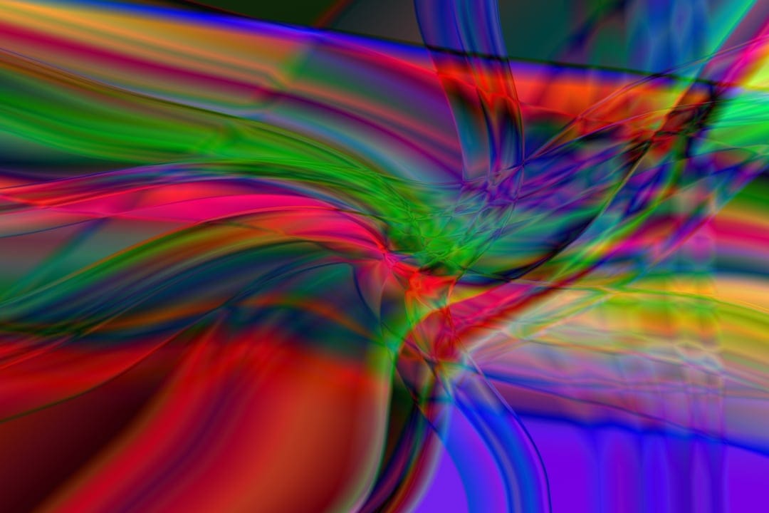 Swirling ribbons of red, blue, and yellow light intertwine in a fluid, psychedelic pattern of liquid motion.