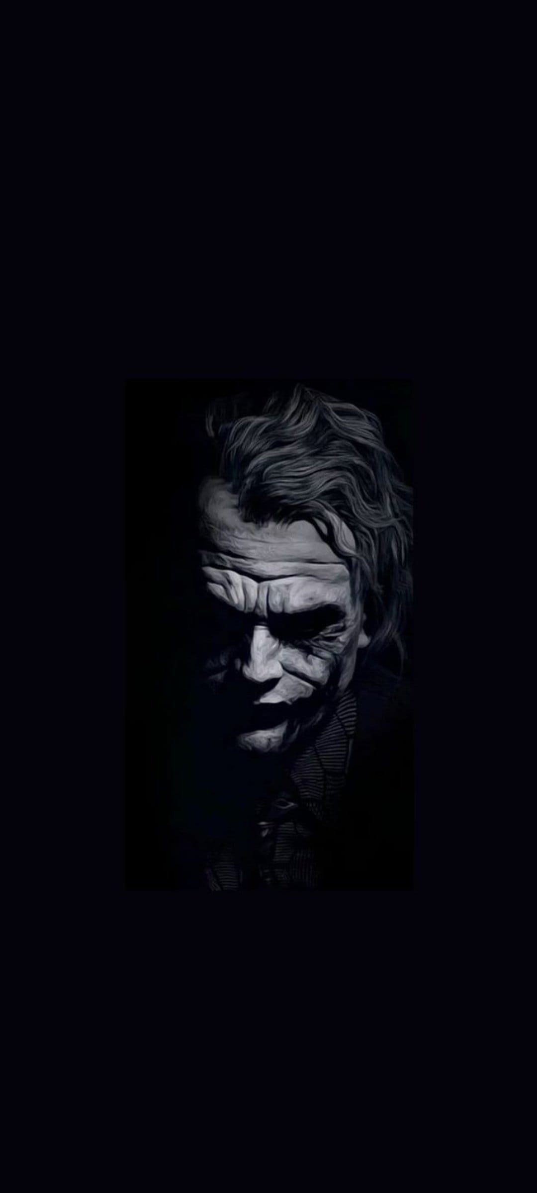 Joker with smeared makeup and a haunting grin faces forward in a dramatic black and white high-contrast study.