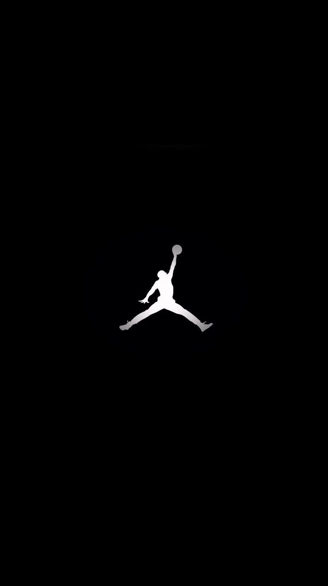 White Jumpman logo silhouette of a basketball player in mid-air against a solid black portrait background.