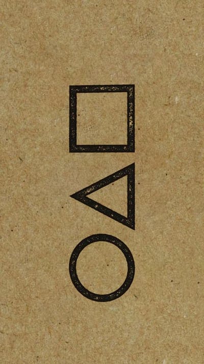 Circle, triangle, and square outlines in black ink appear centered on a rough, textured brown paper surface.
